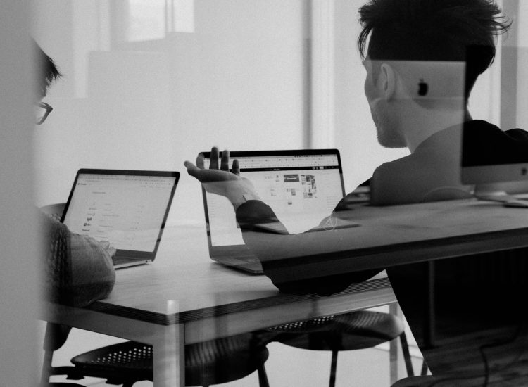 People collaborating on local SEO services strategy using laptops in a modern office meeting.